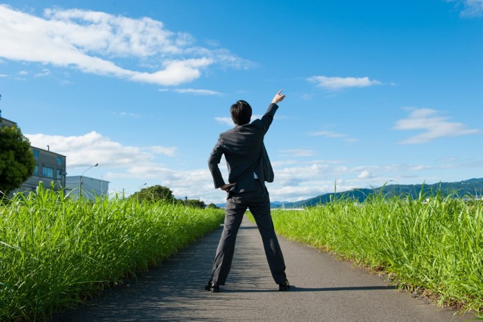 青空に拳を突き上げる人