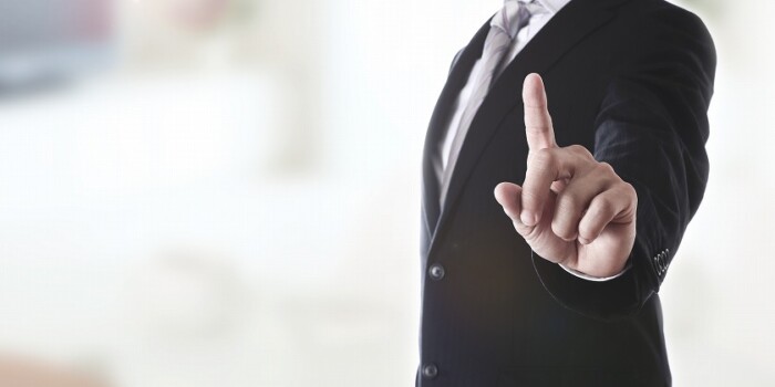 人差し指を見せるスーツの男性